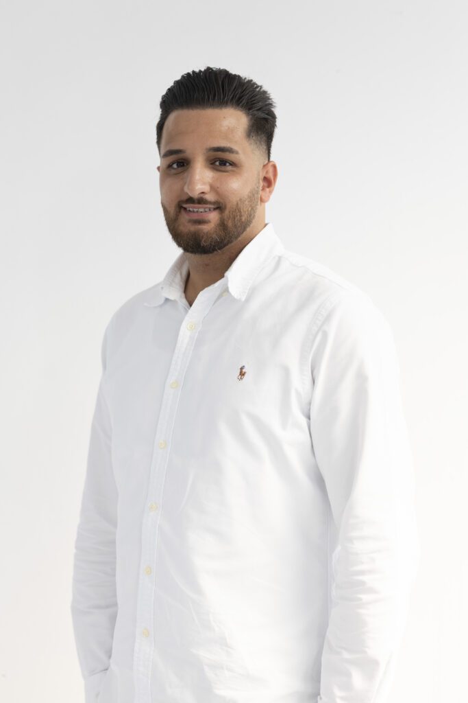 Über uns: Sefkan Tün (Geschäftsführer bei iTrust Automobile) posiert für ein Porträtfoto im weißen Ralph Lauren Hemd.