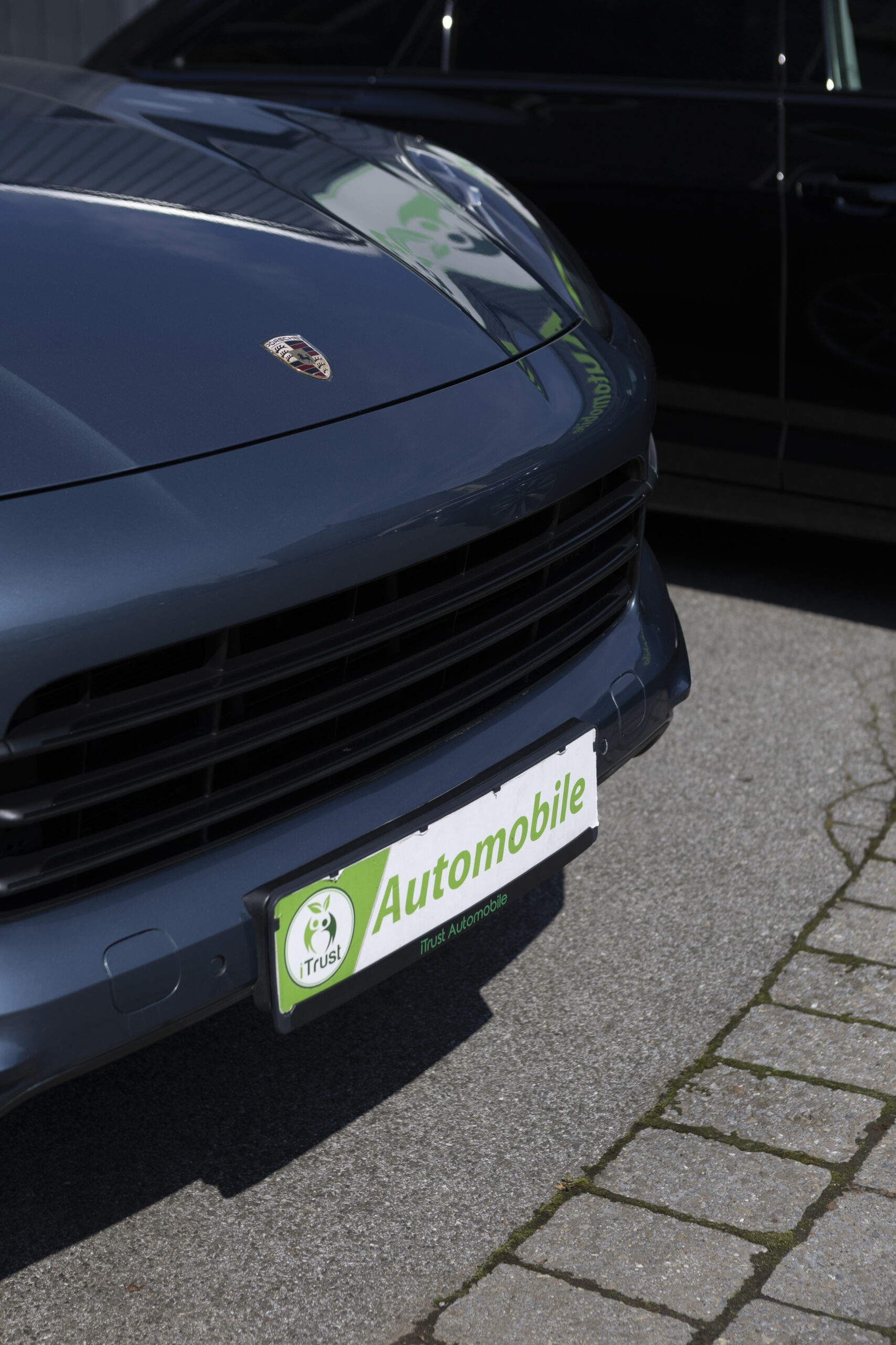 Frontansicht eines dunkelblauen Porsche Gebrauchtwagens bei iTrust Automobile in Solingen.