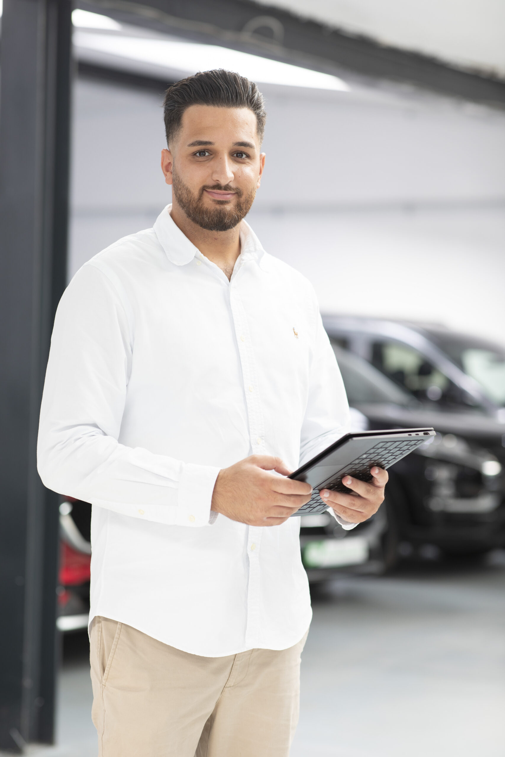 Sefkan Tün mit Tablet als Ansprechpartner für Mercedes Gebrauchtwagen bei iTrust Automobile in Solingen.