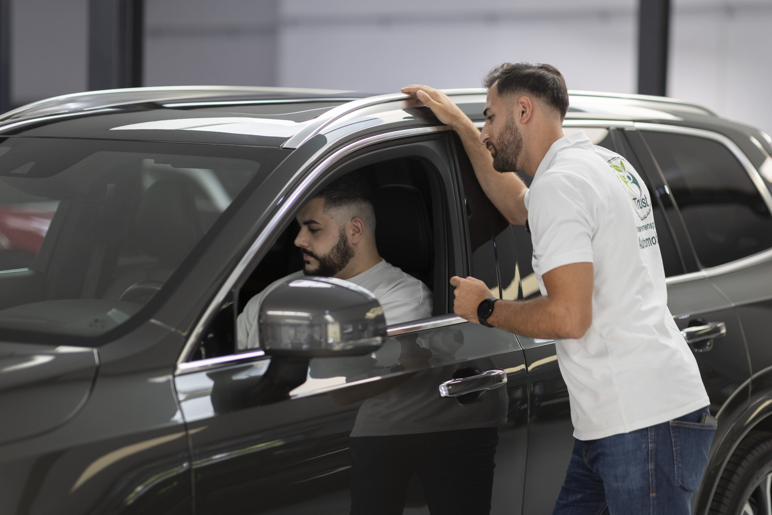 Suleyman Tün von iTrust Automobile berät einen Kunden in seinem Fahrzeug in Solingen.